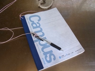 訪れた人が自由に書き込めるノート。テーブル下には過去のバックナンバーが何冊か入っていて、盛況な様子。