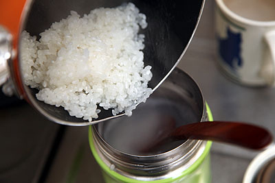 煮立ったら、まだ米が生の状態で予熱したフードコンテナに投入。