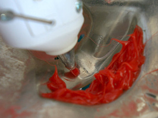 赤いホットボンドはマスクの裏側に盛って形を作る。 