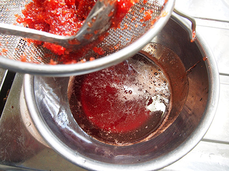 煮えたところで紅ショウガを濾す。