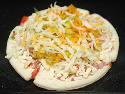 冷凍食品のピザにカボチャの花とチーズをトッピング。