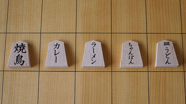無地の駒でオリジナル将棋を作りました。水転写シートを使うときっちりとしたフォントがきれいに駒に乗ります。餃子だろうが焼き鳥だろうが、駒にいい文字で書くと様になっちゃうのが不思議。(安藤)