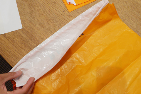 白いテカテカの袋につや消しのオレンジで印刷をかけてる。袋の端の口の部分に印刷がかかってないのはわざとらしい。たしかにジーパンの耳っぽい。