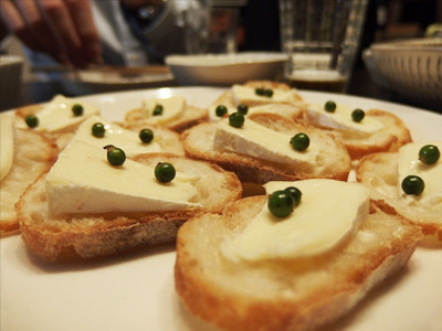 【1】白カビチーズと生コショウのブルスケッタ こちらは助っ人料理人ツジムラさん作である。シャレたビストロで出てきそうな一品。チーズと生コショウが異様に合う。