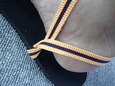 紐の締め付け具合を調整しながら、かかとにかかる紐の下を、下から上に向かって通す。