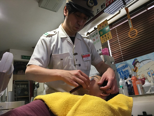 駅員さんの恰好をした人に顔を剃ってもらっている。不思議な光景