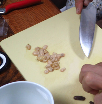 幼虫に切り込みを入れるとプリッとフンのかたまりが出てくる。調理法によってはさっと茹でたり蒸したりしてから絞り出す方法もある。
