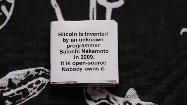 裏面に答えが「2009年にサトシ・ナカモトという謎の人物によって発明されました。オープンソースだから誰のものでもないんじゃよ」
