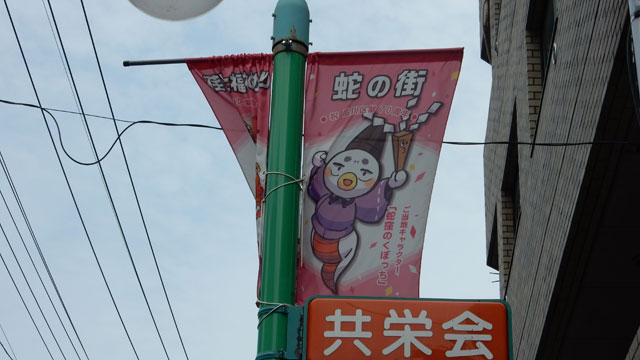 商店街に出た。そしてまた神社を連想させるキャラクターの旗。