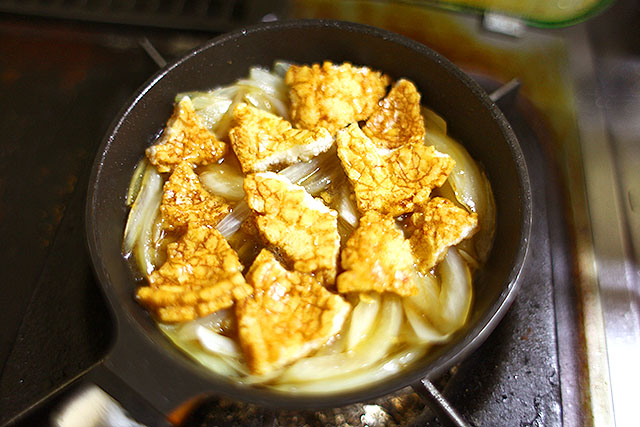  玉ねぎを炒めて、創味の麺つゆで火を通したら歌舞伎揚を入れて煮込む。