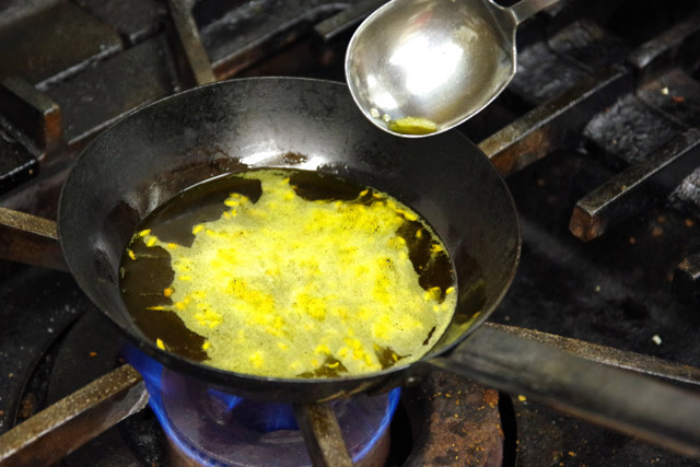 マスタードオイルでパンチフォロンをテンパリングした油で麺を和える。